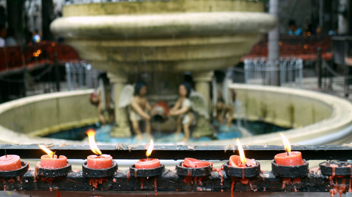 Devotees light candles in prayer at the basilica. (USJR MassCom intern Nel Mozol)
