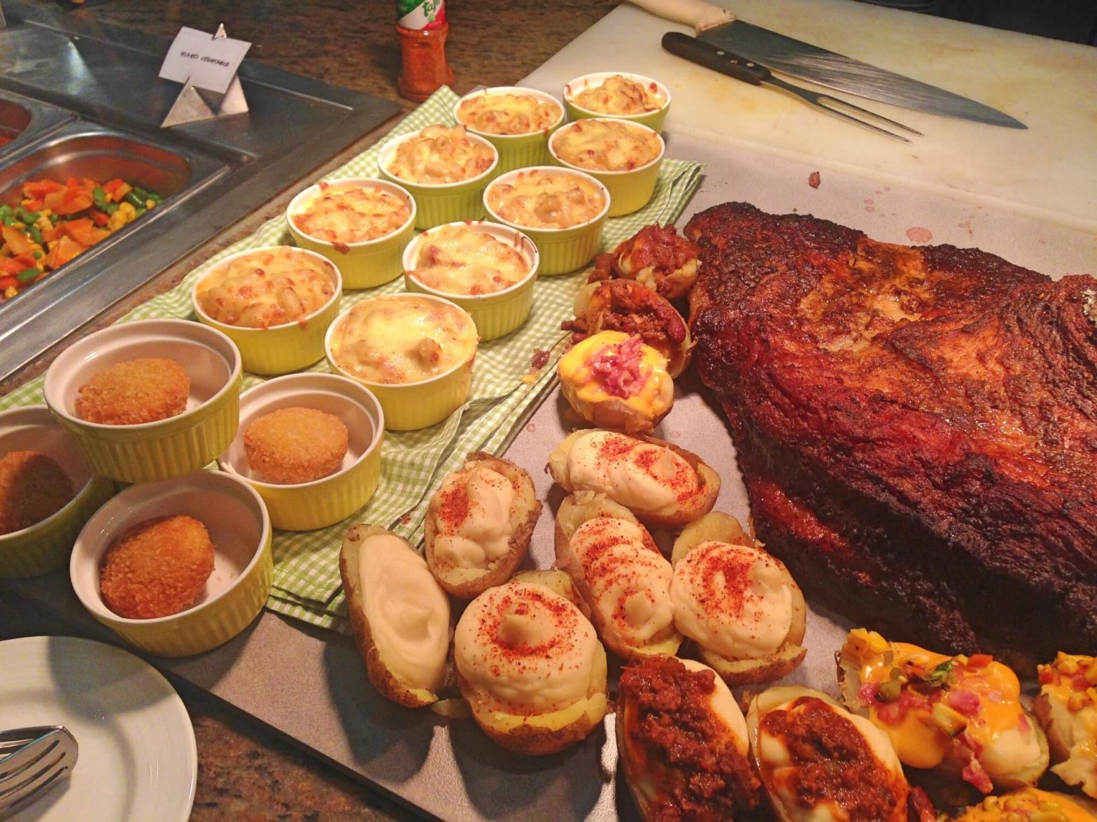 Smoked meat with baked potatoes and mac n' cheese.