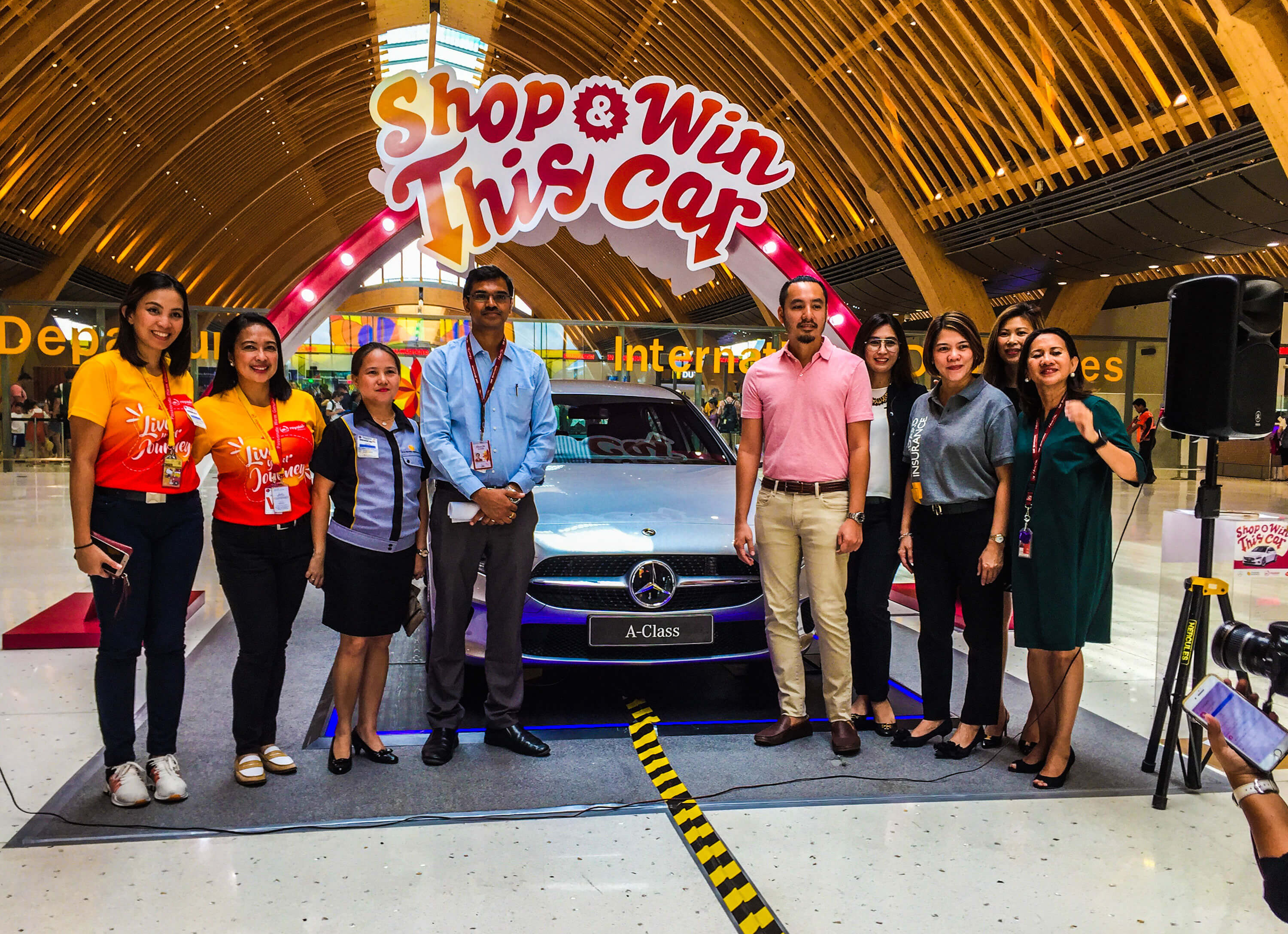 MCIA PROMO. Unveiling the grand prize for the Shop and Win raffle promo in Terminal 2 of the Mactan Cebu International Airport are (from left) Royal Air Marketing Manager Joanna Marie Garcia, Royal Air VP Commercial Margarita Obejas, Standard Insurance Marketing Manager Anna Lisa Opay, Standard Insurance Vice President Joy Alampay, GMCAC Chief Commercial Advisor Ravishankar Saravu, Global Star Owner and President Edward Onglatco, Global Star General Manager Ritchell Selma, Global Star Sales & Marketing Manager Aimee Ting, and GMCAC Deputy Chief Commercial Officer Ma. Cristina Angan.