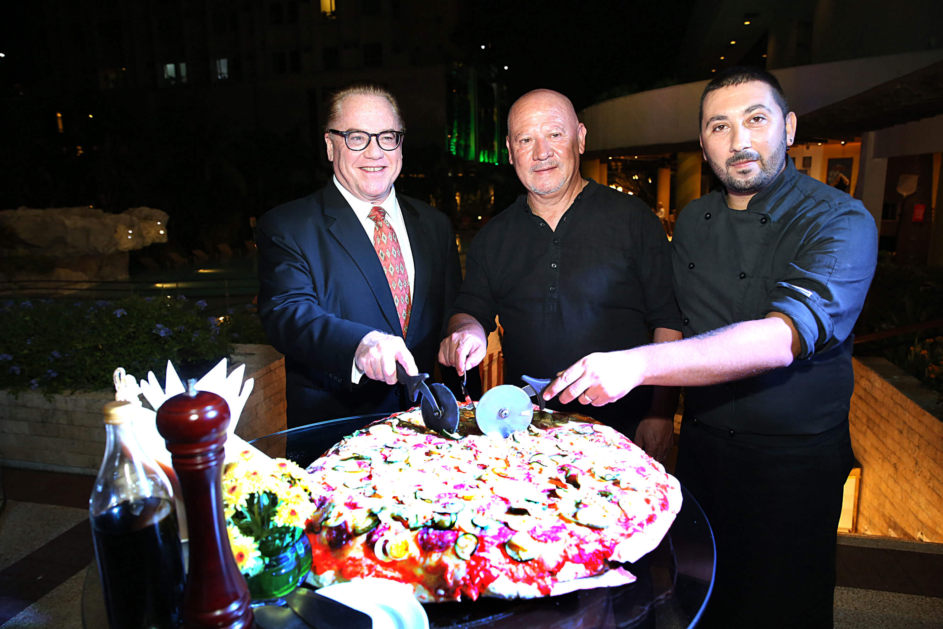 PIZZA SLICING CEREMONY. Opening La Dolce Vita with a pizza-slicing ceremony are (from left) Marco Polo Plaza General Manager Brian Connelly and guest chefs Giuseppe Genco and Luca Genco.