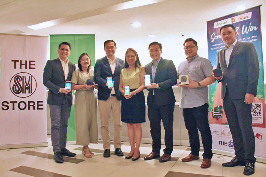 SCRATCH AND WIN. (From left) Denis Albano, AVP, SM Business Center Operations (BCO); Mercedes Ñieva, Sr. Manager, SM Business Center Operations (BCO); Eugene Saw, SVP, SM Store Business Unit; Precy Katigbak, VP, Smart National Key Accounts; Rexmond Fang, Sr. Manager, Smart National Key Accounts; Rubledo Martinez, Business Unit Head, Eleksis Marketing Dealer Sales Group (Bose); and Louie De Guzman, AVP, Smart National Key Accounts during the announcement.