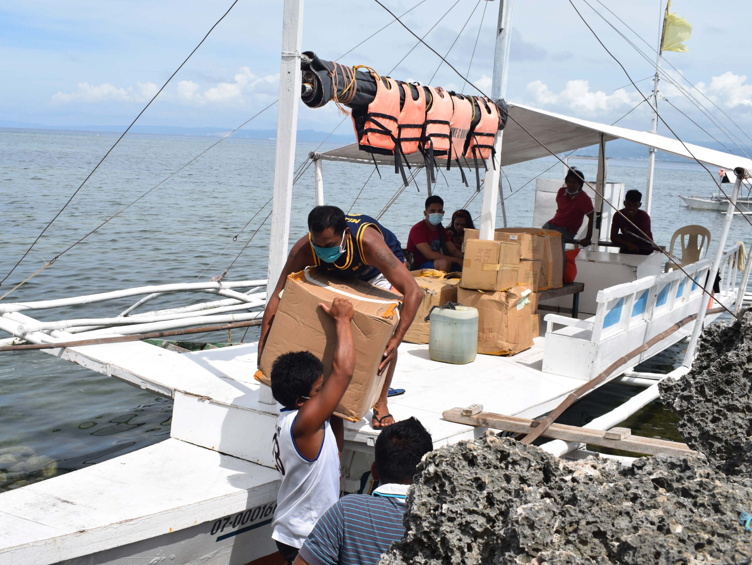 Unloading of the boxes from the boat on the way to Gilutongan Integrated School.