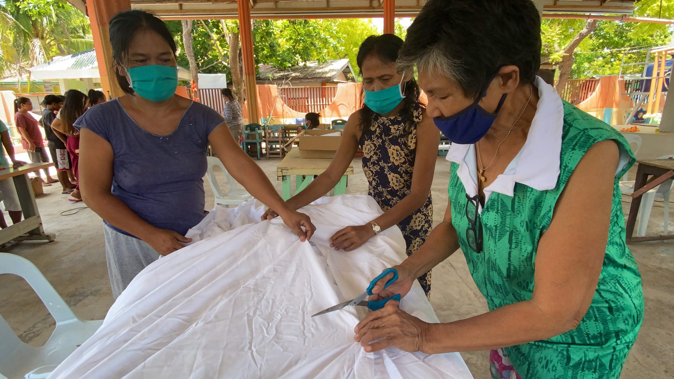 Volunteers portioning the linen to start sewing the face masks.