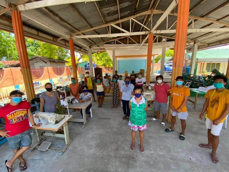 Gilutongan Island residents gathered in their school courtyard to start making masks.