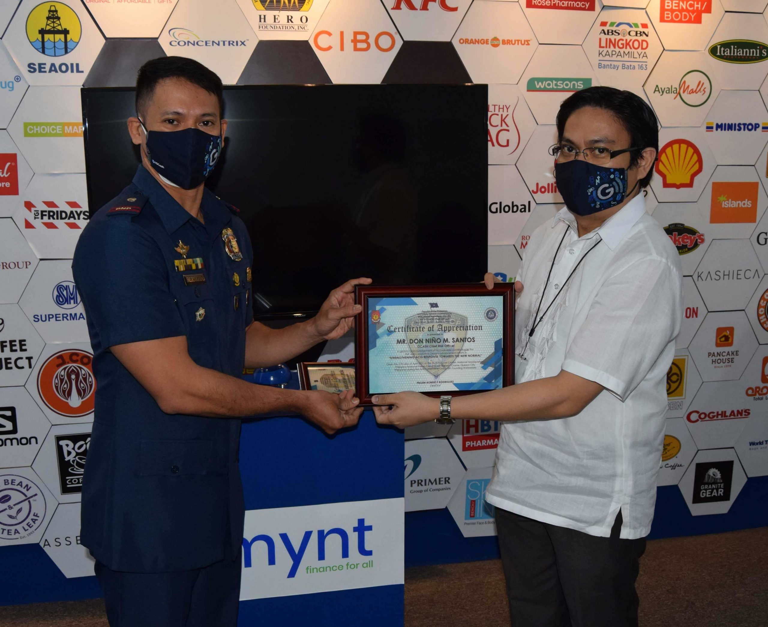 Chief Risk Officer Don Nino Santos receives the plaque of recognition from Police Lieutenant Michael Bernardo.