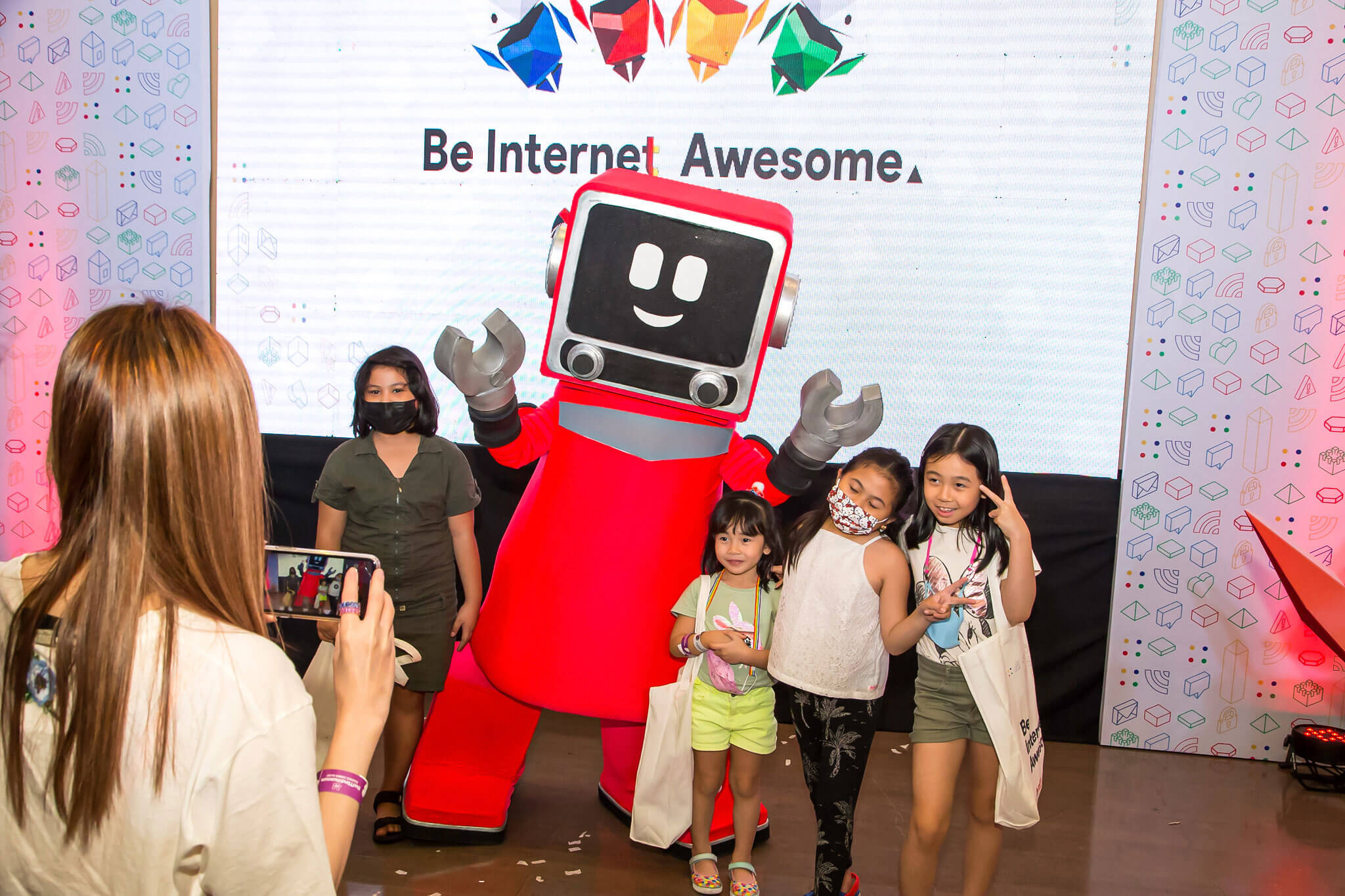 Children posing with Be Internet Awesome’s Robo-berto.