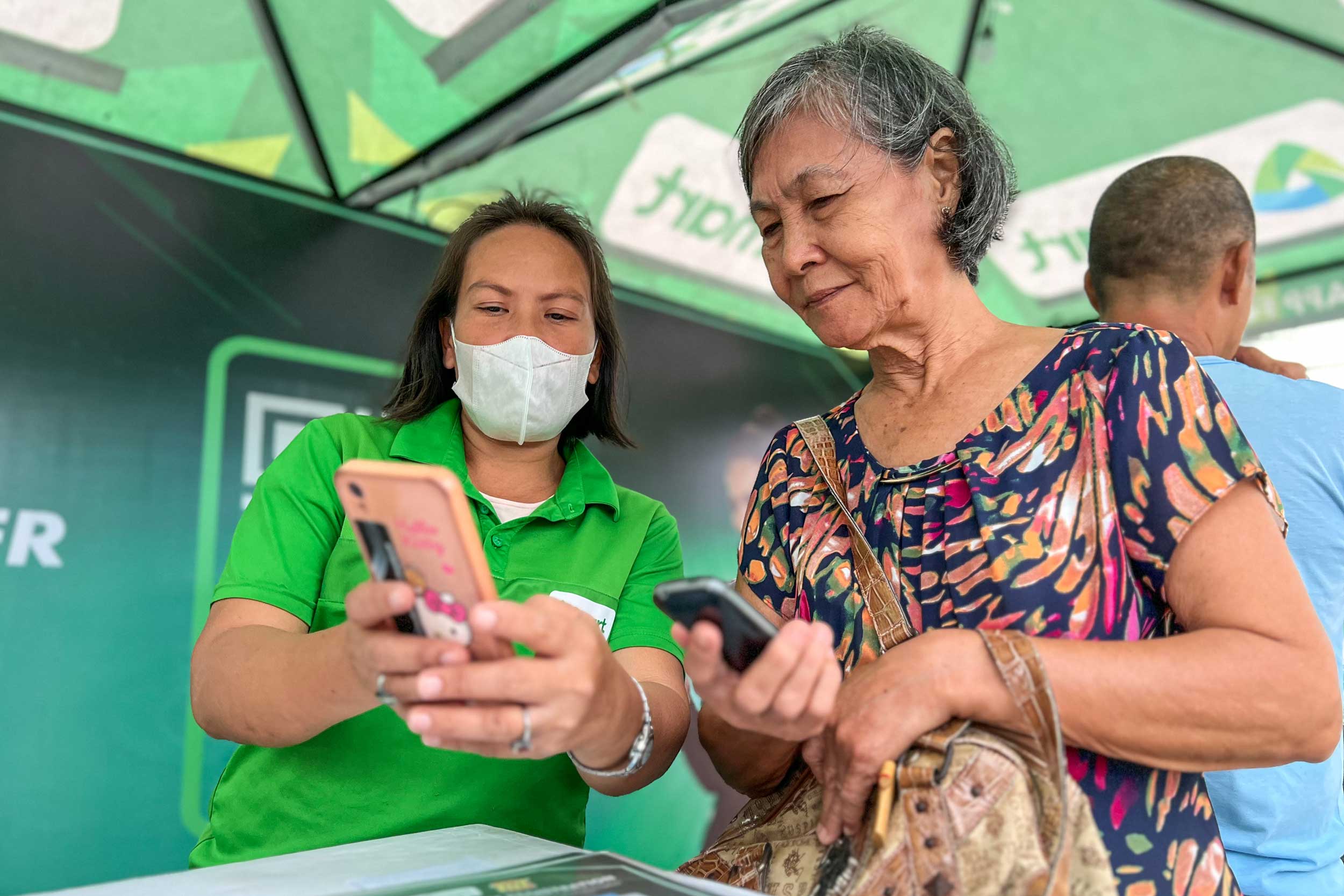 A senior citizen seeks assistance for SIM registration from a Smart Agent manning the booth at Plaza Independencia.