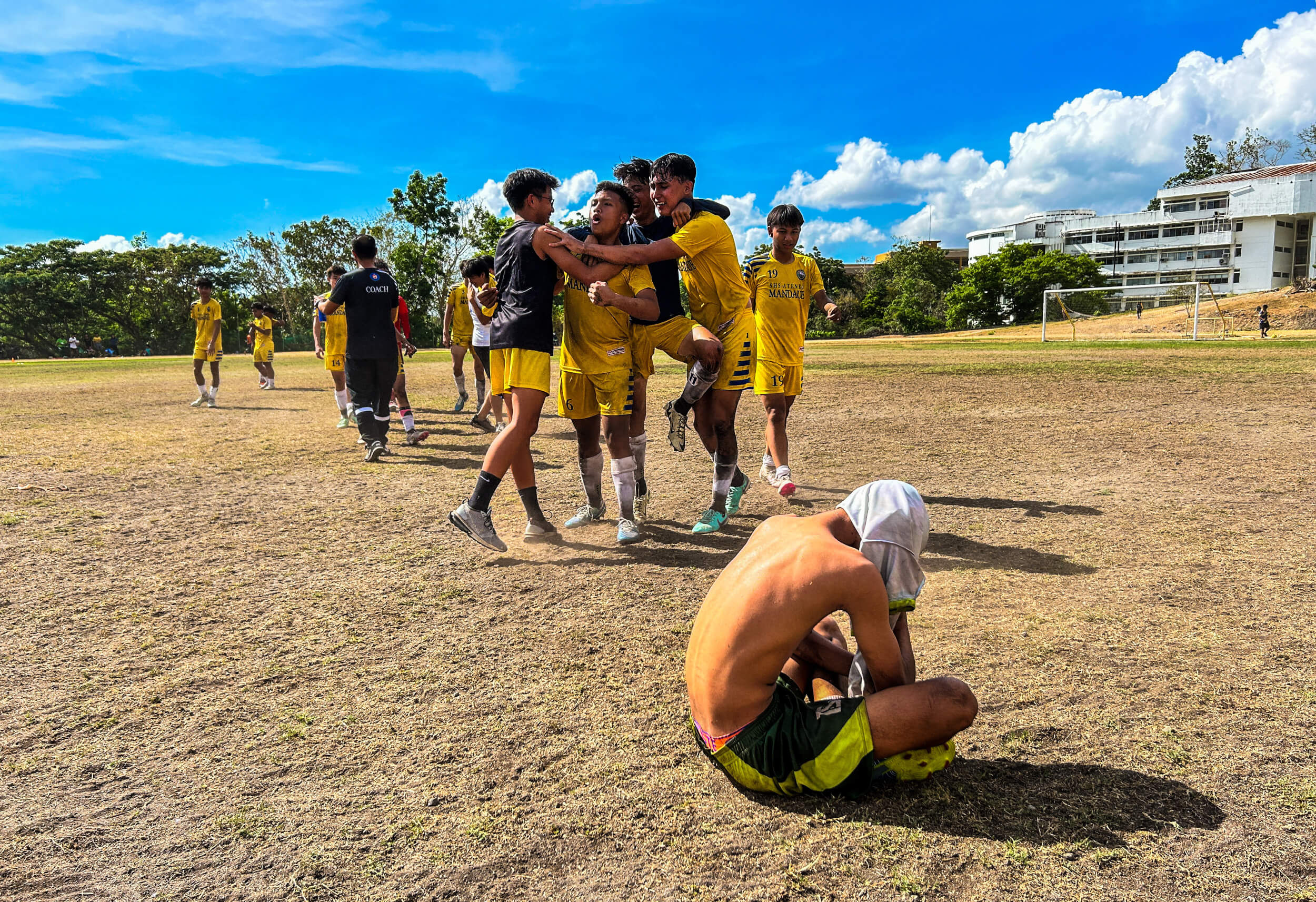 AGONY OF 2ND PLACE. A Bohol Province player covers his head as he cries at the final whistle of the CVIRAA 2024 football championship match as members of the winning SHS-Ateneo de Cebu celebrate.