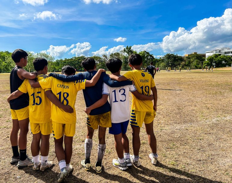 PRAYING. Substitute players of SHS-Ateneo de Cebu huddle and pray the rosary as they nervously watch the closing minutes of their championship match.
